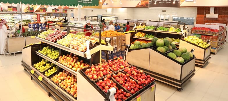 امرأة تقوم بشراء الخضروات في السوق.